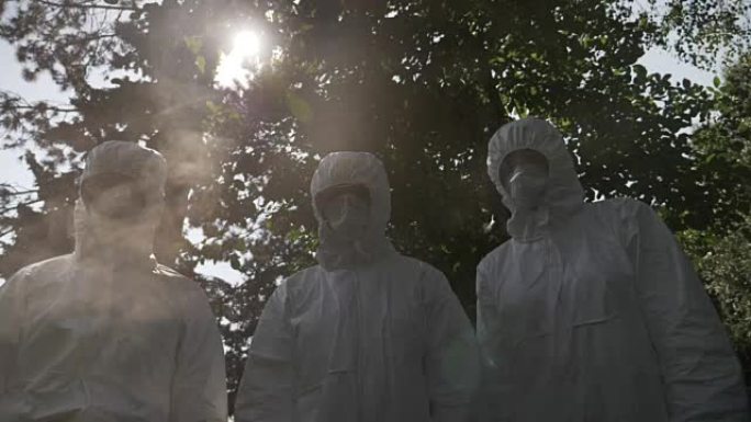 Hazmat技术员工程师工人被防护服和口罩覆盖，静止不动，被有毒气体烟雾污染