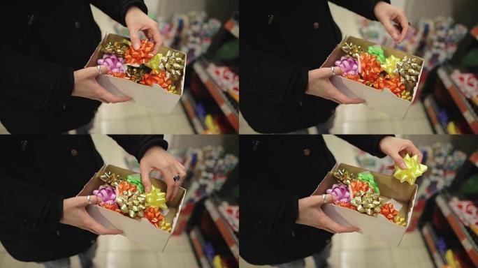 圣诞树上的圣诞女人购物装饰。一个年轻迷人的女孩在超市里为新年礼物选择蝴蝶结