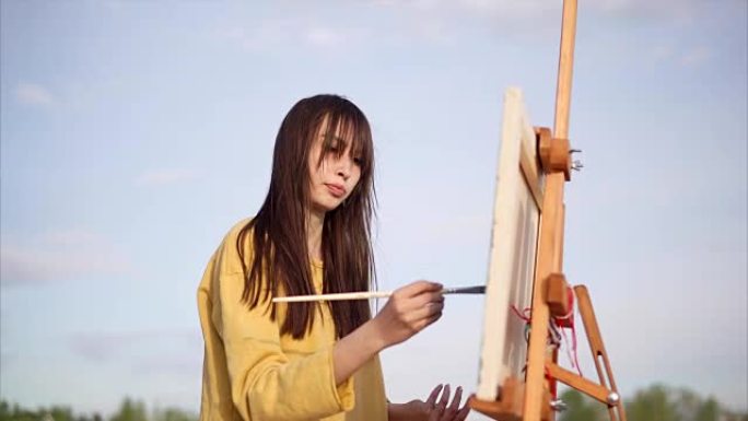 女画家在湖边用油画画画