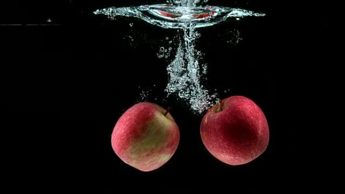 苹果，家蝇，黑色背景下进水的水果，慢动作4K