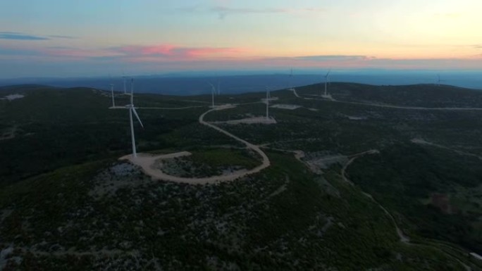 日落时九个用于生产电能的风车的鸟瞰图