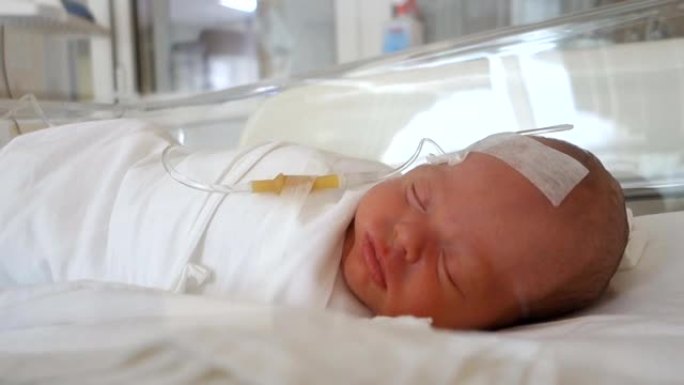 在医院打点滴睡觉的新生婴儿