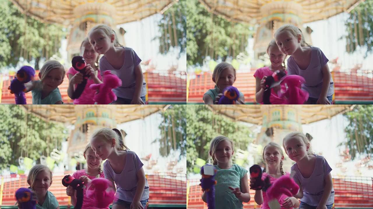 集市上的三个小女孩向镜头展示了他们的奖品