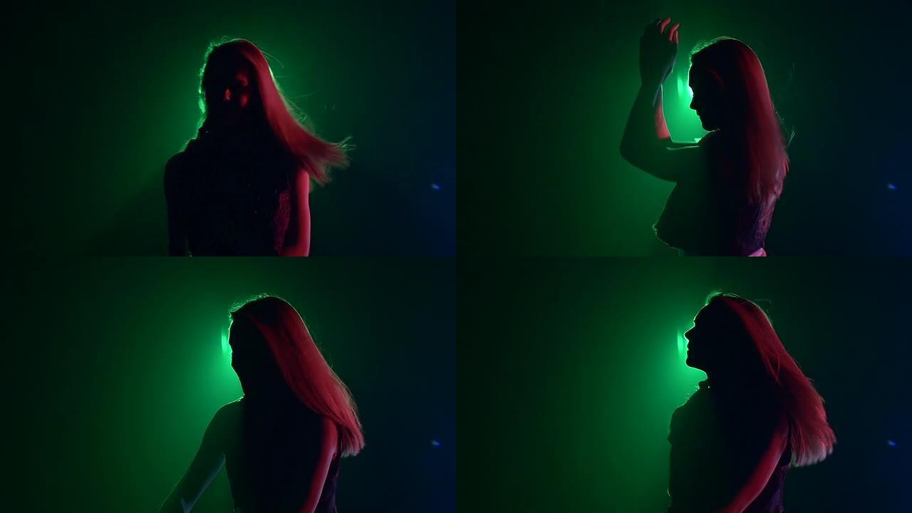 性感金发dj女孩翻转头发，跳舞，剪影，慢动作，绿色背光