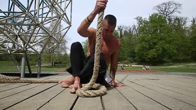 肌肉发达的男子正在爬绳子