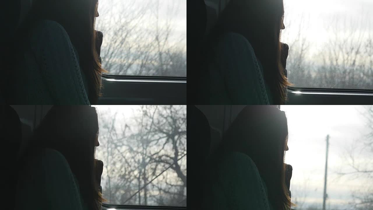 坐火车时看着窗户的年轻女子。在铁路上旅行的迷人女孩的简介。