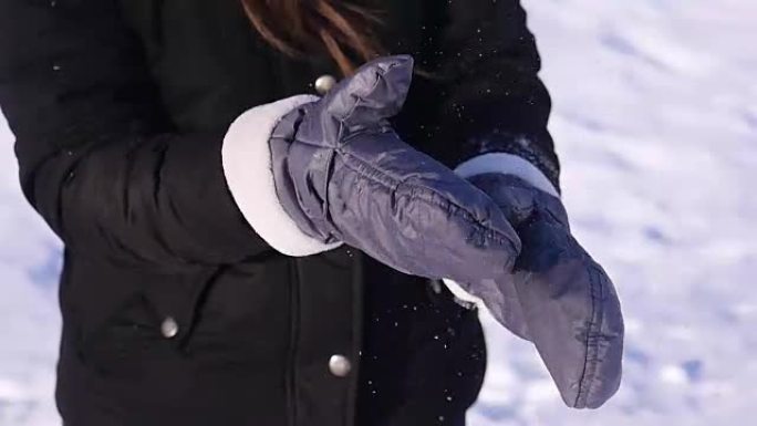 96 FPS慢动作特写镜头，一个年轻女孩从手套上擦雪