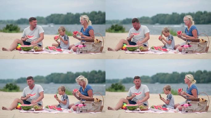 幸福一家人在沙滩上吃西瓜