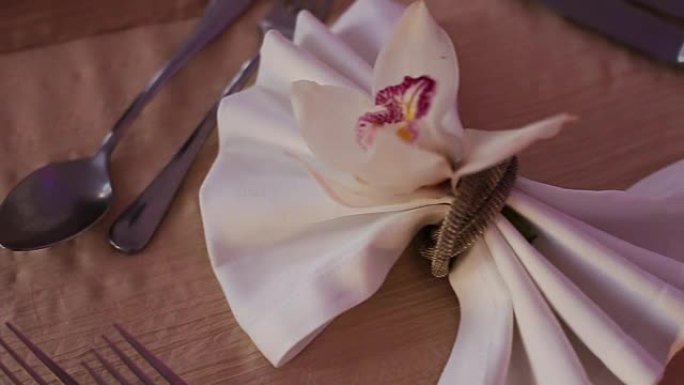 装饰精美的婚礼桌，配有兰花、盘子和餐巾