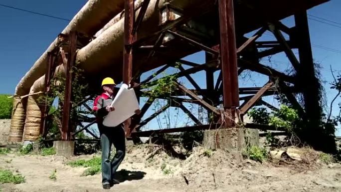 热电站戴着黄色安全帽的工人，配有工程图纸