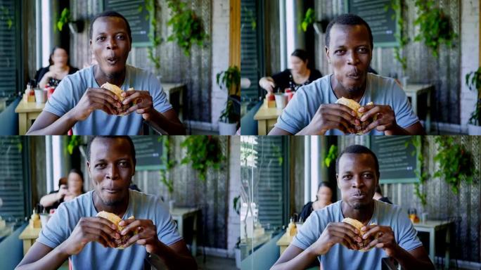 快乐的黑人笑着吃美味的肉汉堡