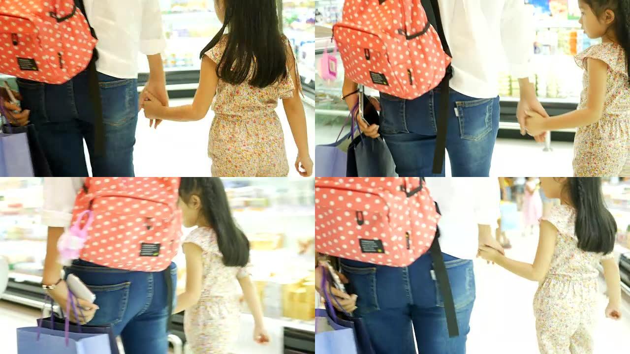 亚洲女孩和母亲在购物中心玩得开心