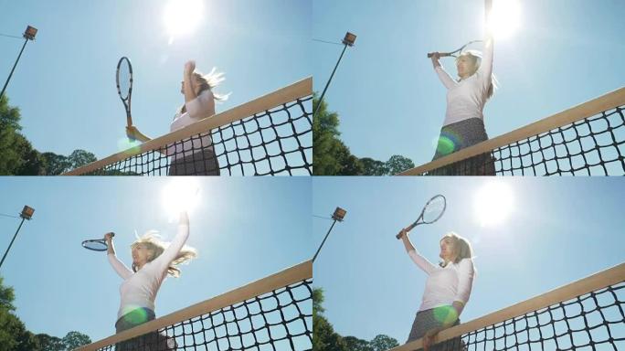 赢得网球比赛后，获胜者女孩跳上网子，欢笑庆祝自己的胜利