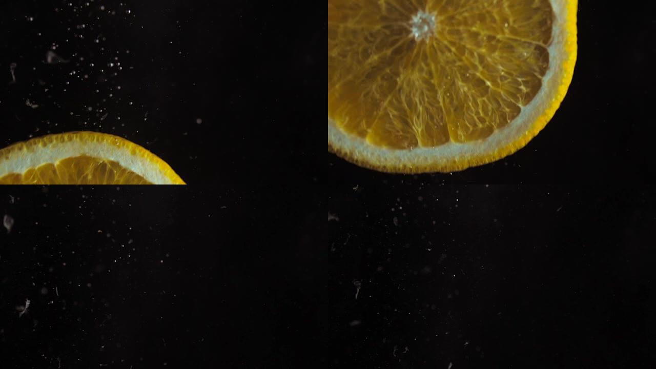 超级特写镜头。宏观观。切成薄片的多汁新鲜橙子以慢动作落入水中。黑色背景上的气泡