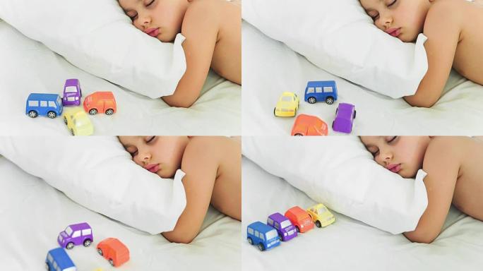 一个孩子睡着了，一辆玩具车在动(定格)