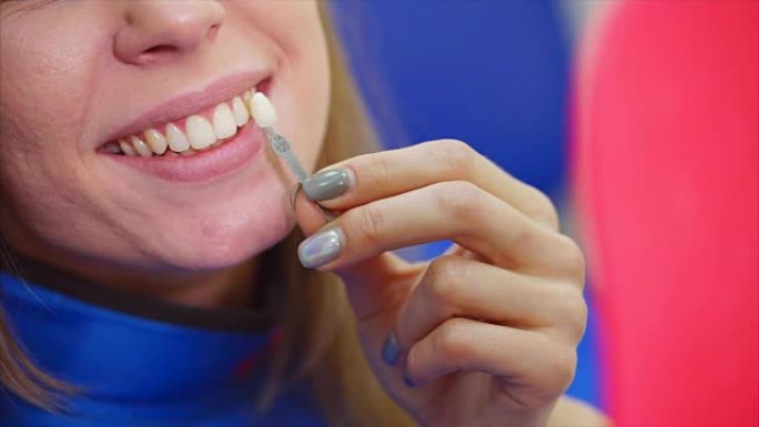 一个女人的嘴巴的特写镜头，她检查她的牙齿是如何漂白的