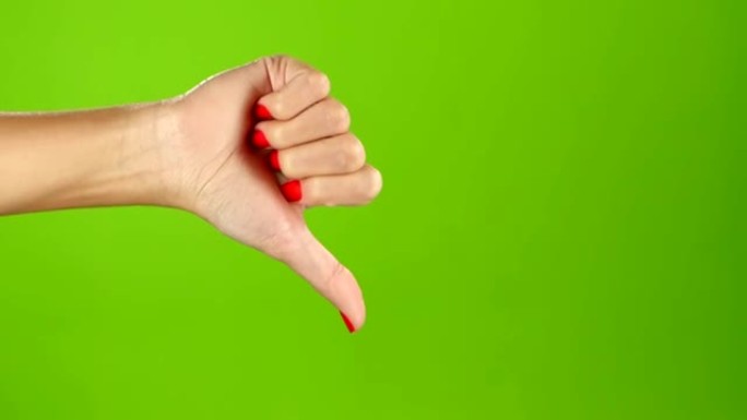 拇指向下的女性手在绿色屏幕的背景。手语