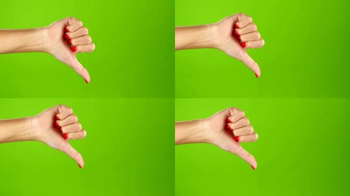 拇指向下的女性手在绿色屏幕的背景。手语