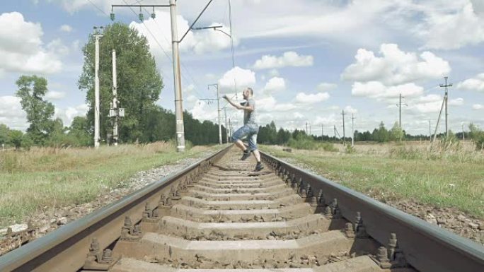 微笑的男子在铁轨上跳着舞