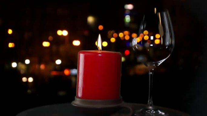 红蜡烛和一杯红酒在城市背景