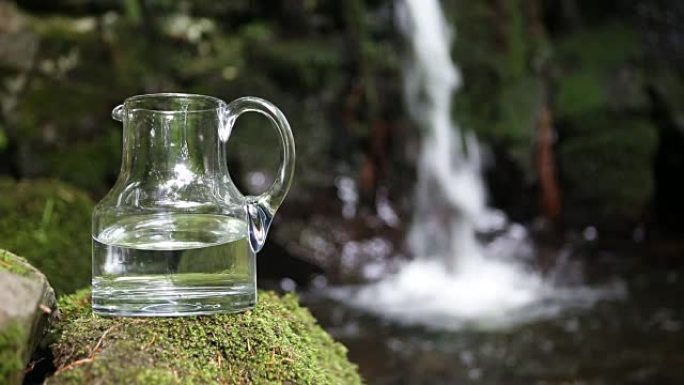 背景为淡水和瀑布的玻璃水瓶