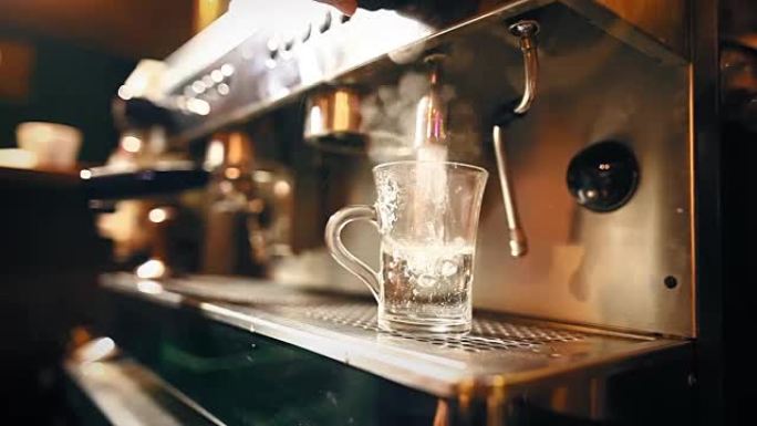 咖啡师在透明的杯子里倒一些开水