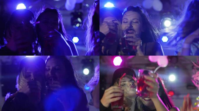 夜生活，快乐的女人在夜间派对上跳舞时喝酒，女孩在卢米埃灯光下的派对上跳舞时喝酒
