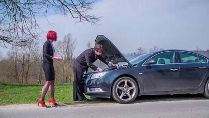 男人站在汽车旁边，开始修理汽车，旁边的一个女人惊慌失措，镜头慢动作。