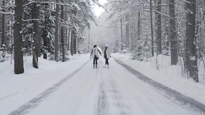 两个快乐的女人走在冬天的森林里