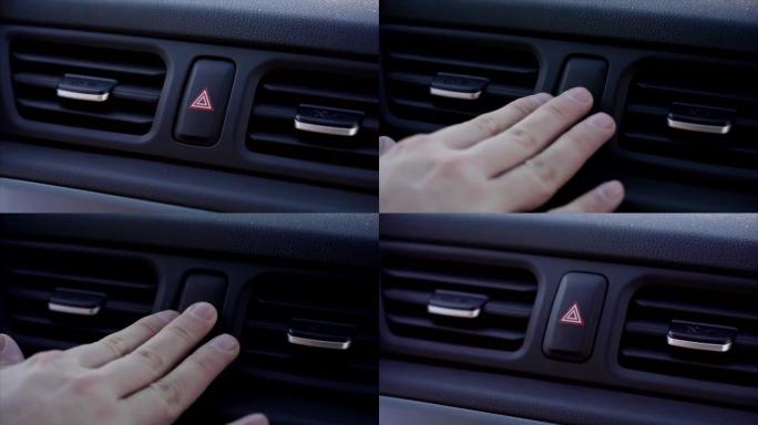 男人手指的特写镜头按下汽车应急灯按钮