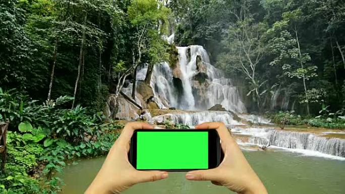 用绿屏显示的智能手机拍摄大自然的视频