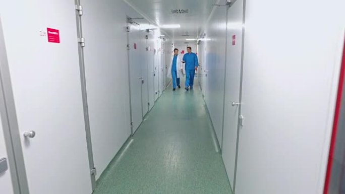 科学家走在实验室走廊上。实验室走廊里的制药工人