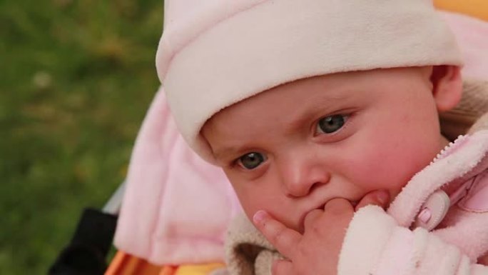 沉思的婴儿吮吸手指的特写镜头