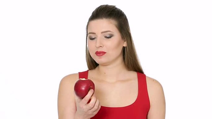 美丽的女孩在白色背景上吃红苹果