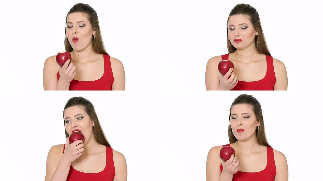 美丽的女孩在白色背景上吃红苹果