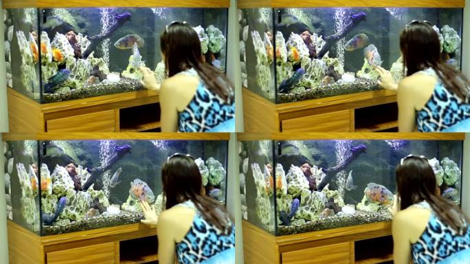 女孩考虑水族馆装饰和鱼