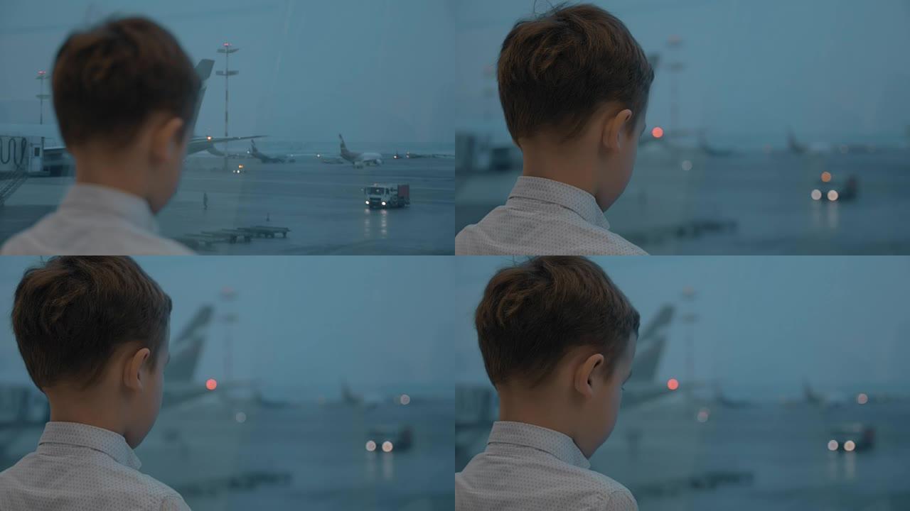 男孩在机场等待飞行并观看飞机