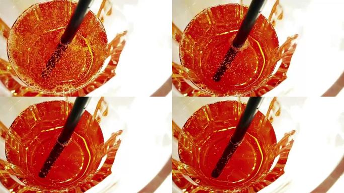 白色桌子上喝一杯开胃酒橙色鸡尾酒的顶部视图，带有碳酸脆的气泡运动，假期和夏季概念