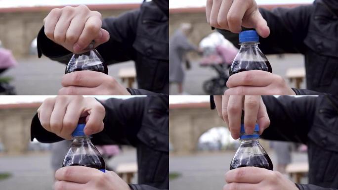 在街头咖啡馆，男人的手从汽水瓶上拧下顶部的特写视图。4k拍摄