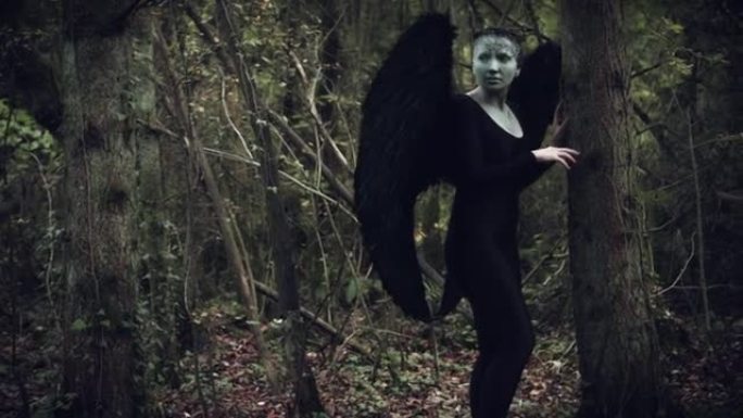 4k万圣节黑天使女人，森林里有黑色翅膀，看起来很害怕
