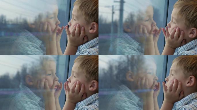 男孩用手看着火车窗外