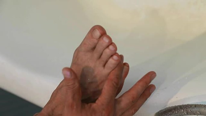 男人在脚上涂奶油。男人在护理他干燥的脚皮肤，涂抹保湿霜。护肤品。男人脚的特写。美容治疗。通过使用特殊