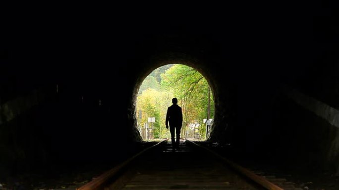 男人走在隧道里，黑暗的轮廓，寻找出路