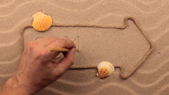 用绳子制成的指针在沙子上手写的夏季铭文