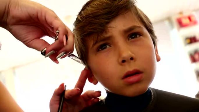理发的孩子。8-10岁男孩在理发师理发
