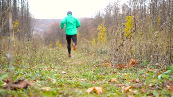运动男子慢跑越野跑。在鼓舞人心的秋季景观中越野跑步时，在户外训练和锻炼。运动动机。慢动作。