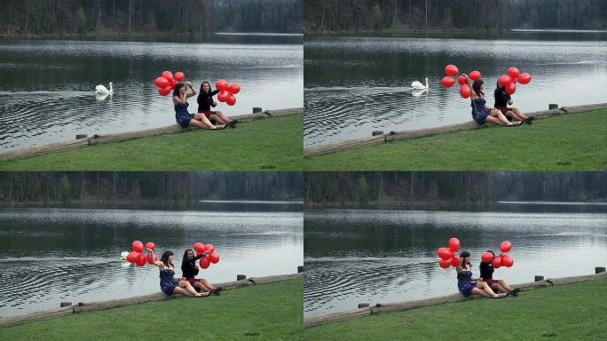 在湖中享受红色气球和天鹅的女性朋友