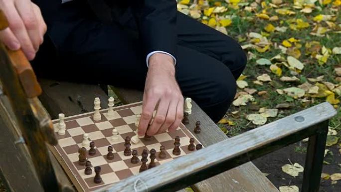 穿着西装的人在秋季公园下棋