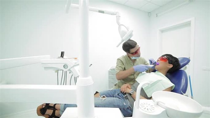 牙医将紫外线光聚合物密封固定在其上