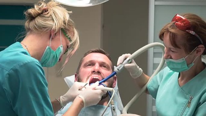 牙医和助手从牙齿上去除牙结石。稳定。